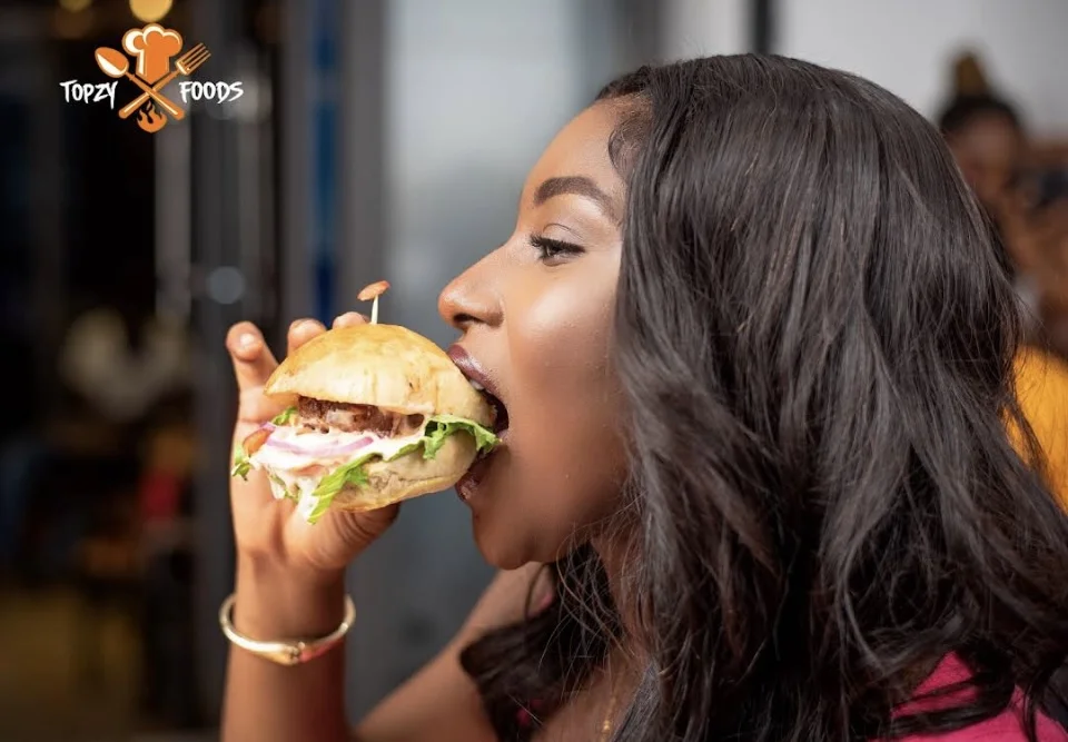 A customer enjoying a Topzy Foods burger