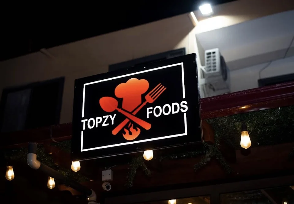 The illuminated Topzy Foods restaurant sign